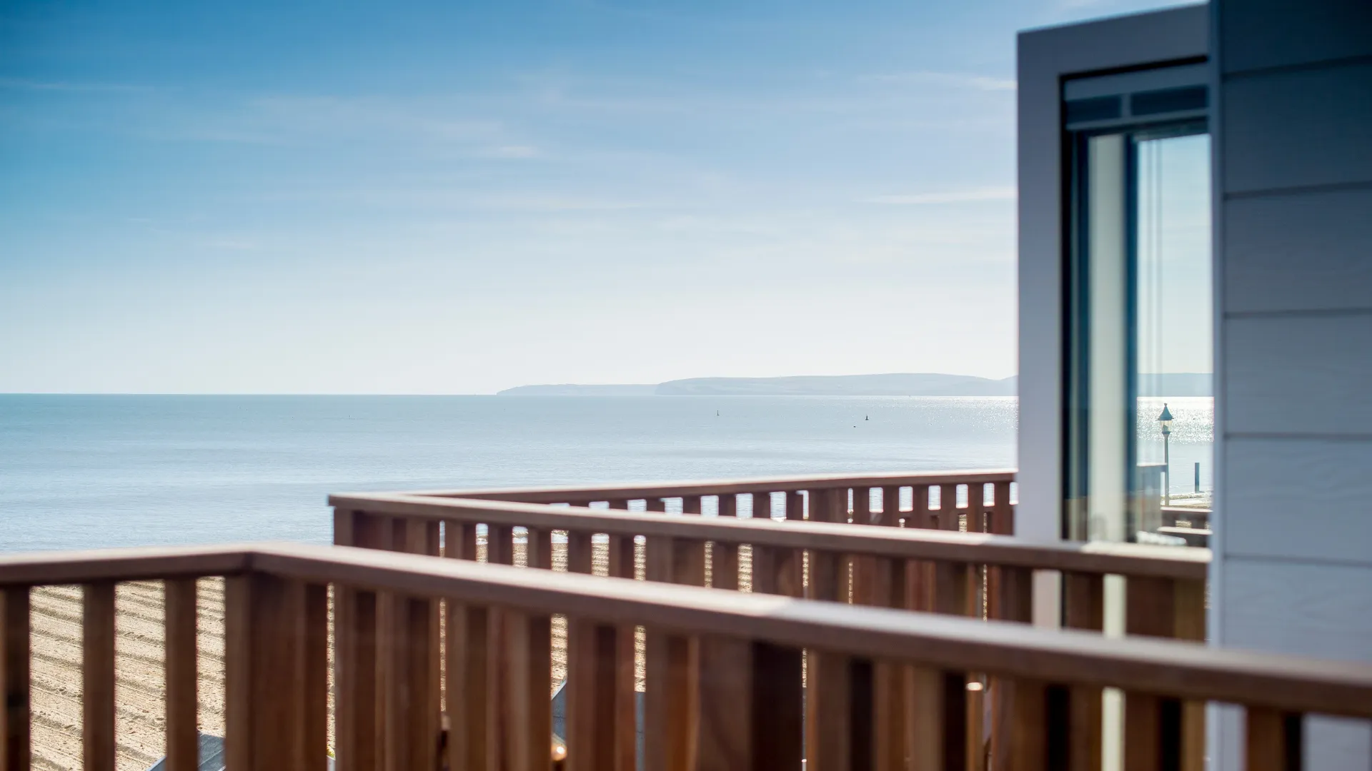 Friends holding wine glasses on south facing deck overlooking beaches