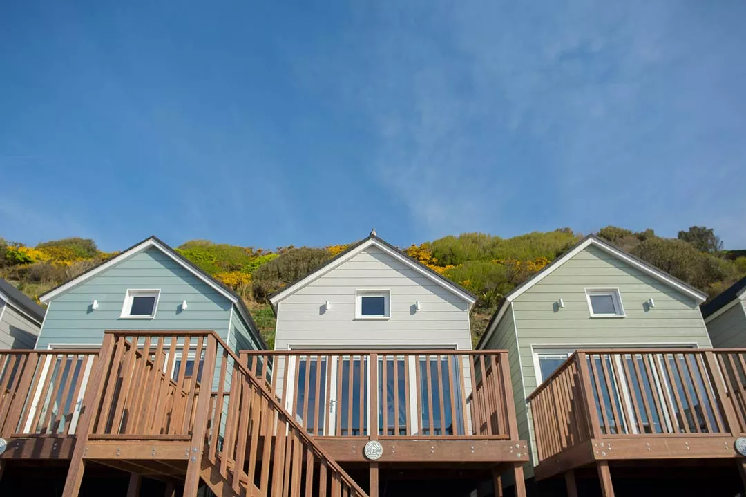 Two deckchairs and a table laid up for breakfast on the hut balcony