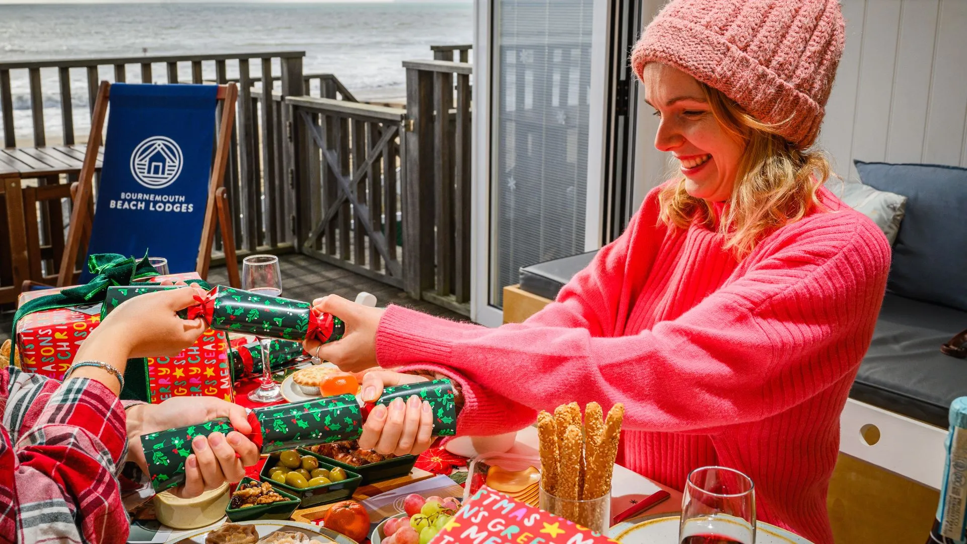 Girl sitting at table pulling Christmas cracker