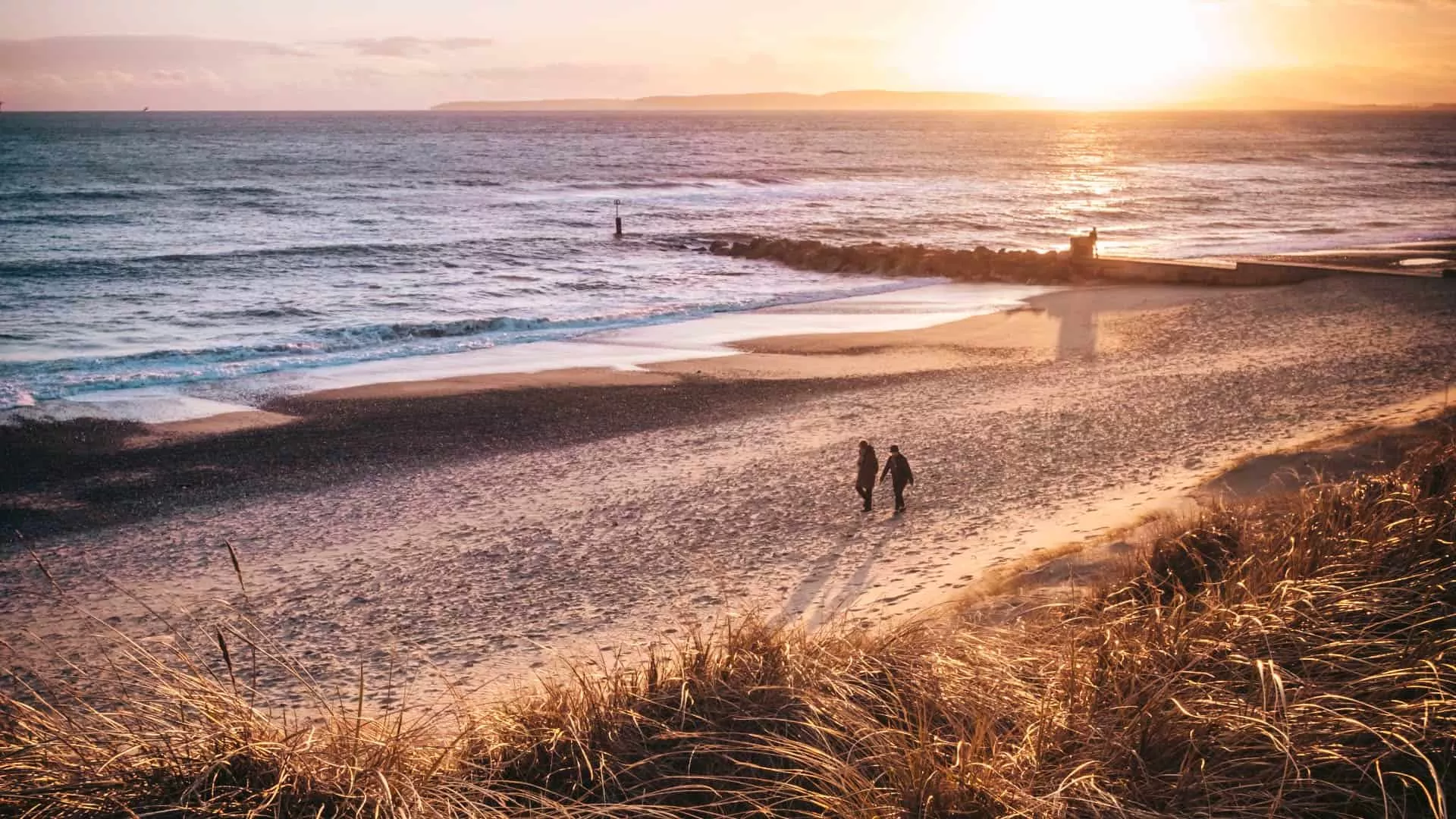 Couple enjoying a relaxing Autumn walk on the beach
