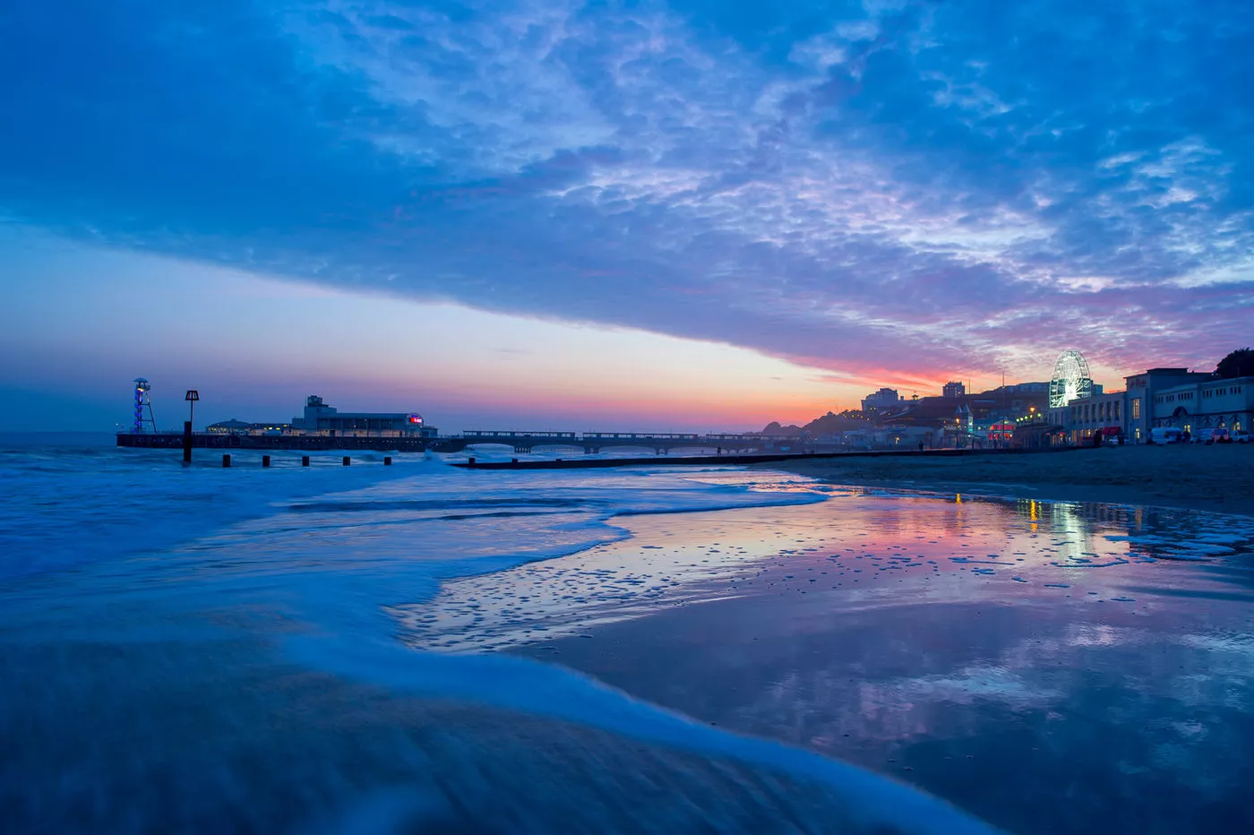 Long exposure shot of Bournemouth pier and beach with a purple and red sky