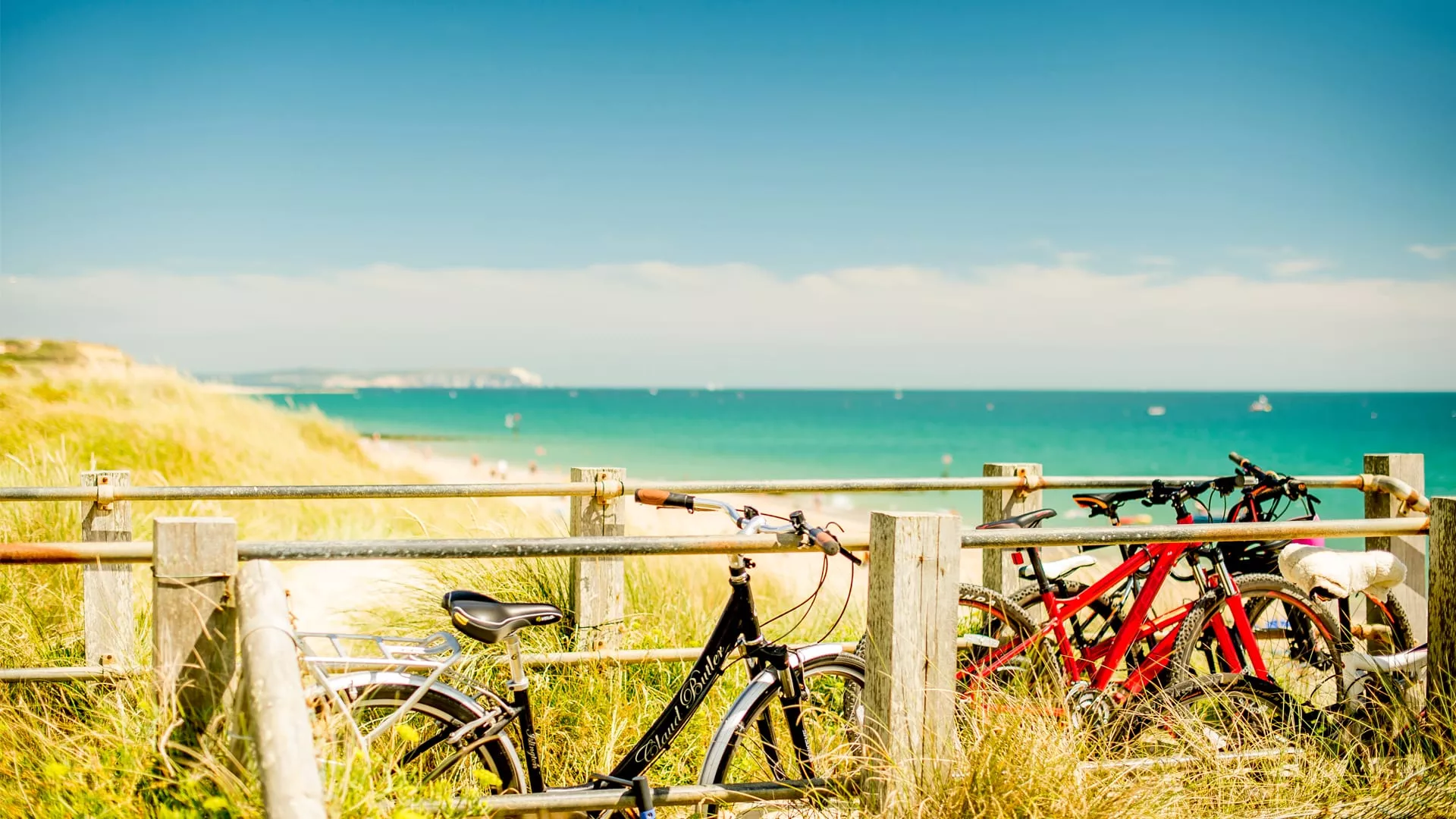 Bikes against railings overlooking the sea on the clifftop at Hengistbury Head