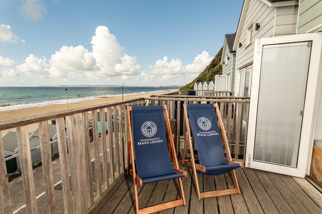 Branded deckchairs on a lodge balcony with a sea view in the background 