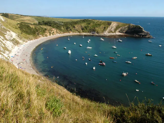 Boats moored up in Lulworth cove during the summer