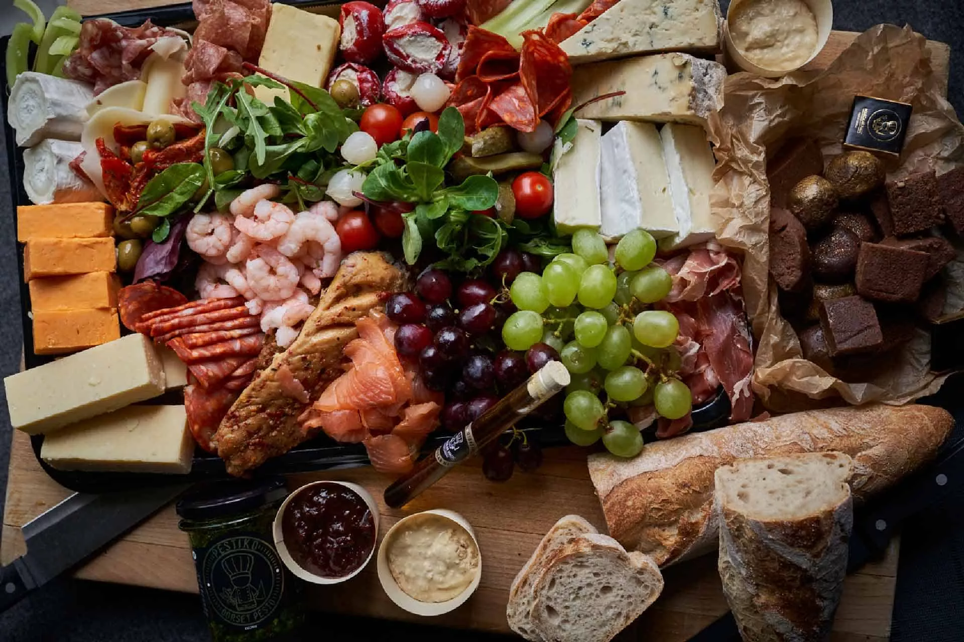 Tasty platter filled to the brim with meats, cheeses, grapes and other food