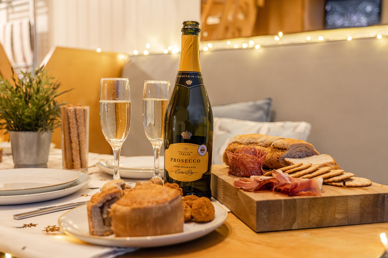 Wine and food served for New Year on a beach lodge coffee table.