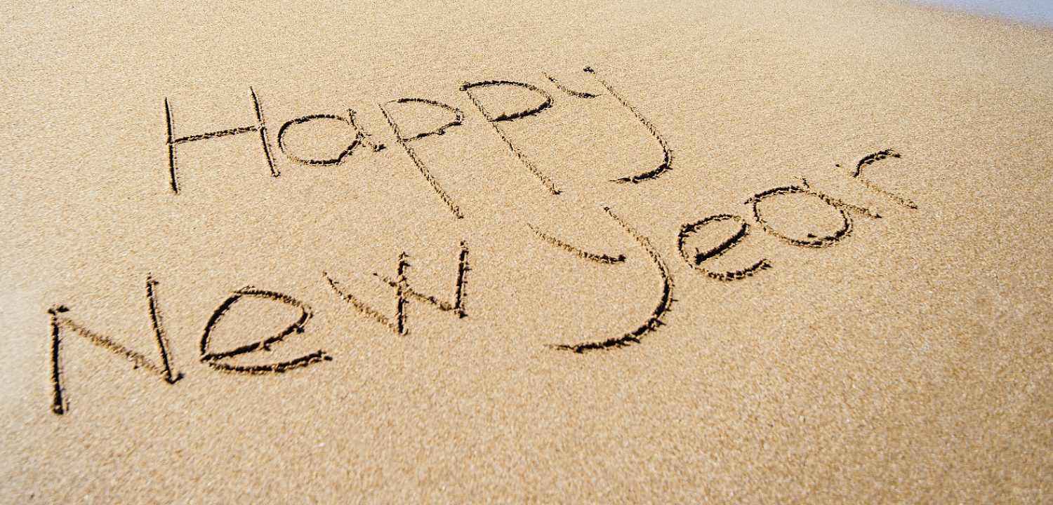 The words Hally New Year written in the sand