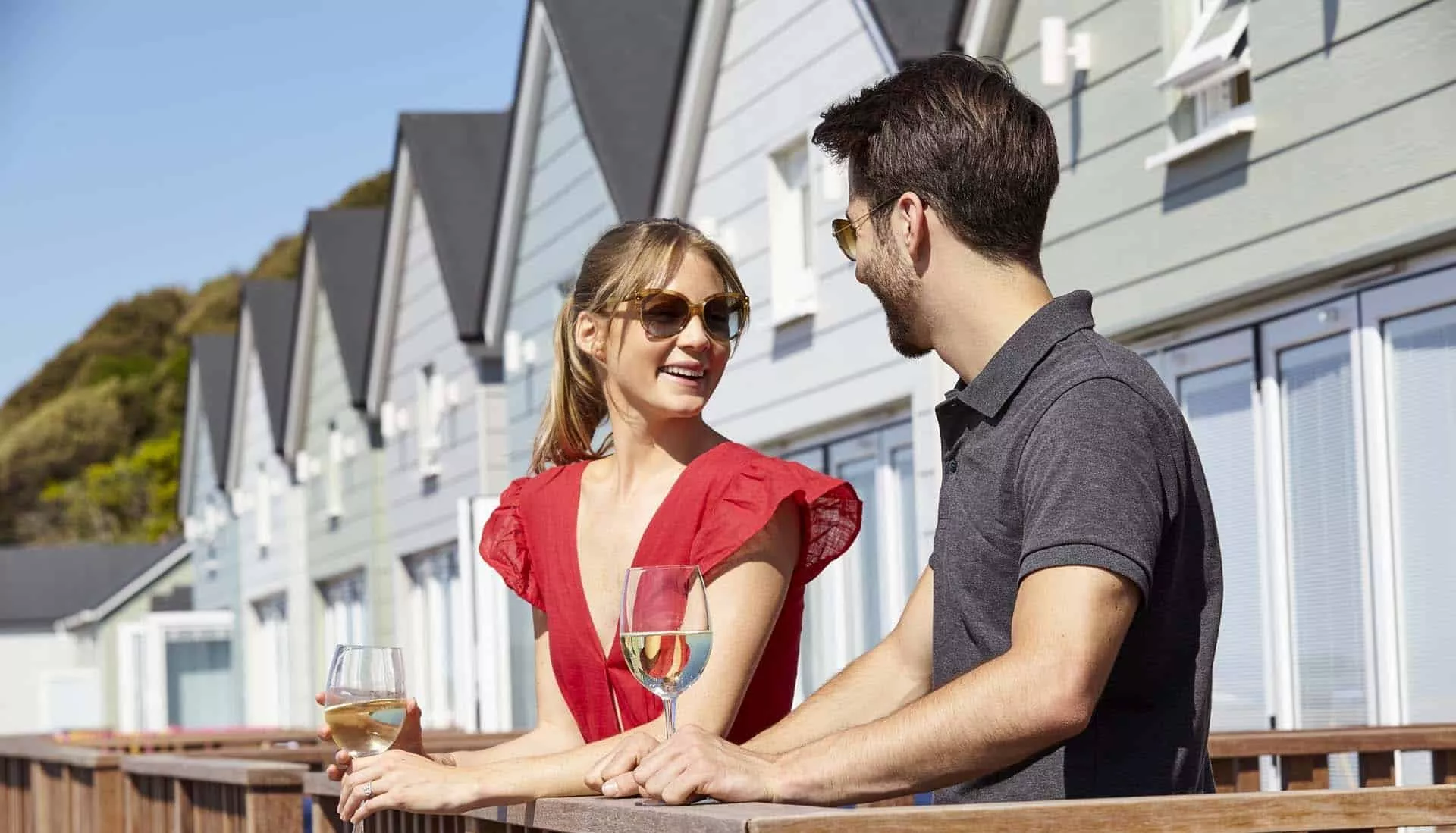 Beautiful couple drinking champagne on the beach lodge terrace