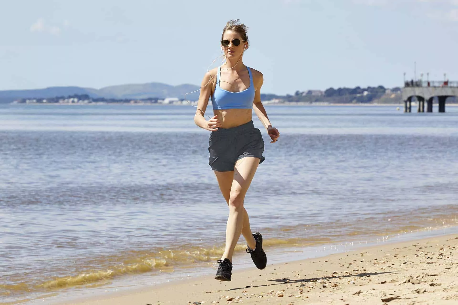 Runner enjoying beachside run on sandy beach near Boscombe Pier